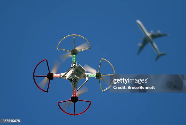 Drone is flown for recreational purposes as an airplane passes nearby in the sky above Old Bethpage, New York on September 5, 2015.