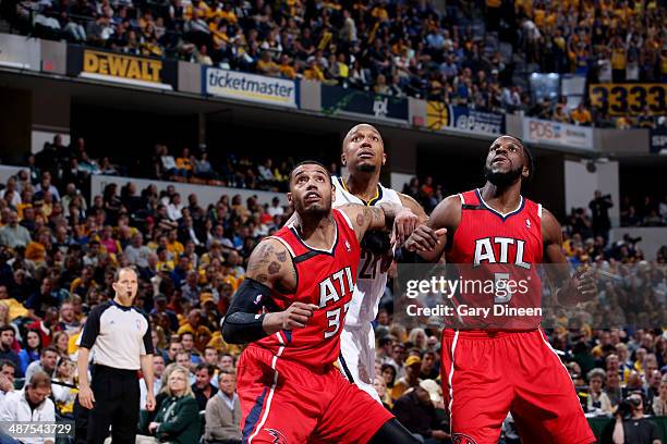 Mike Scott and DeMarre Carroll of the Atlanta Hawks battle for position against David West of the Indiana Pacers during Game Five of the Eastern...