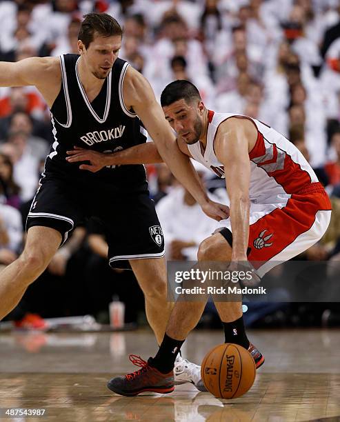 Raptor guard Greivis Vasquez manages to hold possession after he lost the handle while being defended by Nets Mirza Teletovic. Toronto Raptors vs...