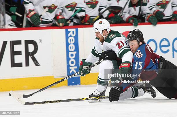 Parenteau of the Colorado Avalanche falls onto Kyle Brodziak of the Minnesota Wild while playing for the puck in Game Seven of the First Round of the...