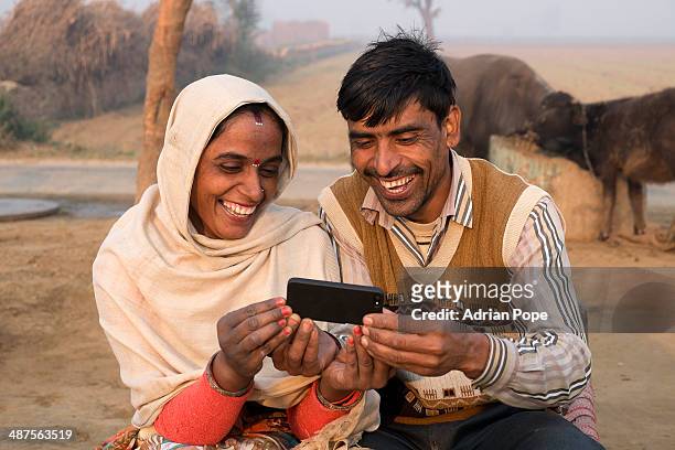 husband and wife looking at smart phone - rural internet stock pictures, royalty-free photos & images