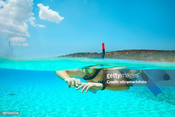 immersione avventura giovane uomo facendo snorkeling mezza metà laguna turchese mare - half underwater foto e immagini stock