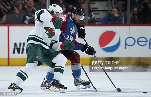 Mikael Granlund of the Minnesota Wild and Marc-Andre Cliche of the Colorado Avalanche pursue the puck in Game Seven of the First Round of the 2014...