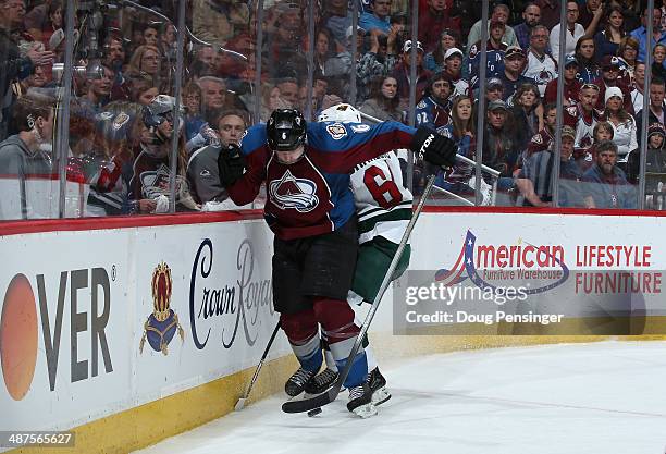 Erik Johnson of the Colorado Avalanche and Mikael Granlund of the Minnesota Wild battle for control of the puck in Game Seven of the First Round of...