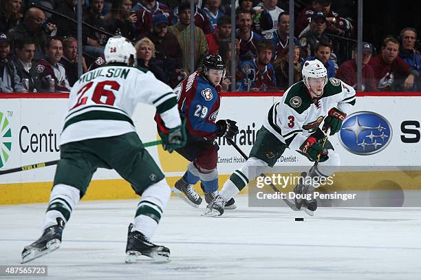 Charlie Coyle of the Minnesota Wild controls the puck against Nathan MacKinnon of the Colorado Avalanche as Matt Moulson of the Minnesota Wild...