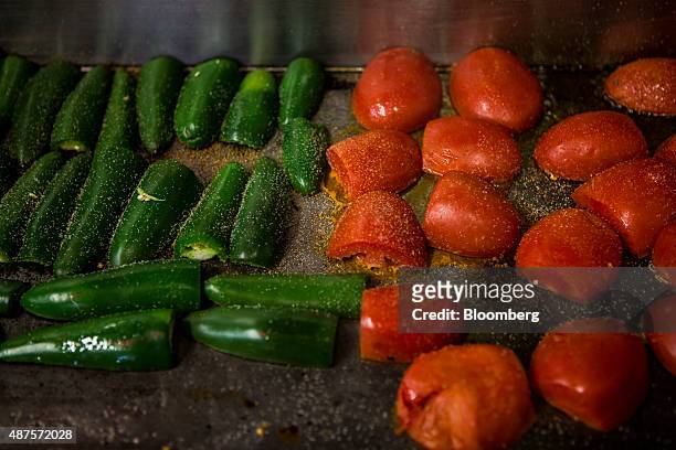Green chiles and tomatoes are grilled during the preparation of a hot salsa at the Camello Gitano Lebanese food truck at the Street Food Center in a...