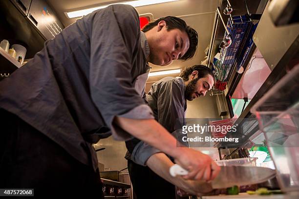 David Barquet, owner and chef of the Camello Gitano Lebanese food truck, right, and Domingo Groba work in the truck at the Street Food Center in a...