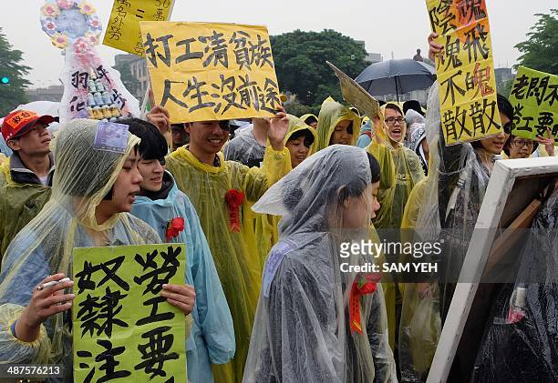 Protesters display placards reading "no futures" during a May Day rally in Taipei on May 1, 2014. Thousands of workers marched from the presidential...