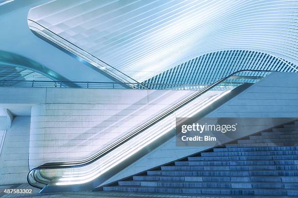 illuminated escalator outside futuristic train station illuminated at night - escalators stock pictures, royalty-free photos & images