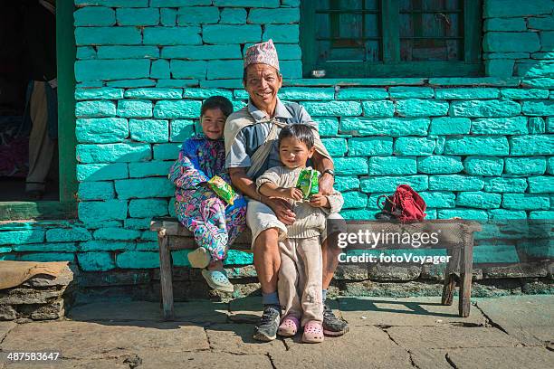 smiling farming family sitting in sunshine high in himalayas nepal - nepal family stock pictures, royalty-free photos & images