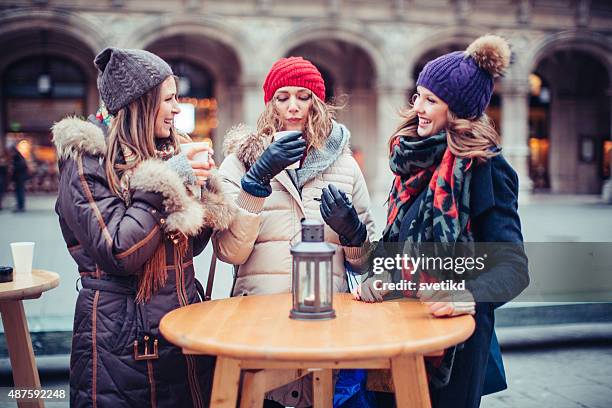 freunde mit heißen getränken im freien im winter-stadt. - glühwein stock-fotos und bilder