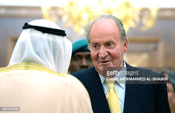 Spanish King Juan Carlos speaks with a Bahraini official during an official welcome ceremony at Gudaibiya Palace, in the Bahraini capital Manama, on...