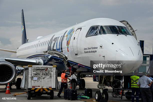 Ground crew member unloads baggage from an Azul Linhas Aereas Brasileiras SA jet at Viracopos International Airport in Campinas, Brazil, on...