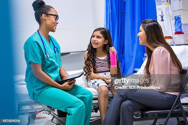 nurse treating patient with brokenn arm in emergency room - childrens hospital stock pictures, royalty-free photos & images