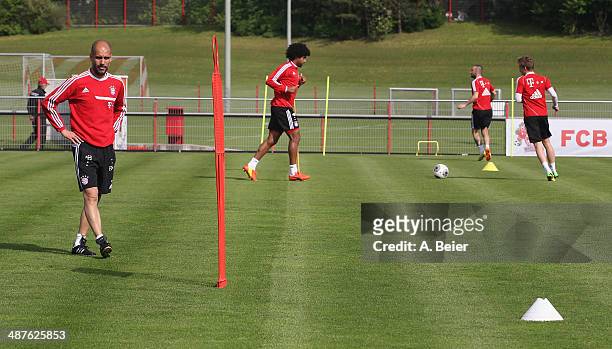 Team coach Josep Guardiola of Bayern Muenchen walks next to Dante, Diego Contento and Mitchell Weiser during a FC Bayern Muenchen training session at...