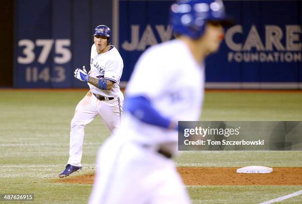 Brett Lawrie of the Toronto Blue Jays circles the bases after hitting a three-run home run with Colby Rasmus in front of him in the eighth inning...