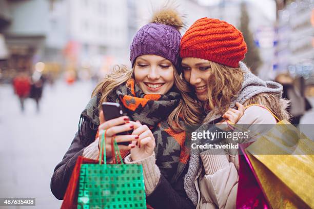 freundinnen einkaufen in der stadt. - christmas smartphone stock-fotos und bilder