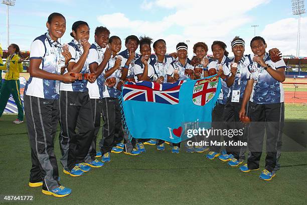 The Fiji girls rugby sevens team pose with their bronze medals after defeating the Cook Islands in the girl rugby sevens bronze medal match at the...