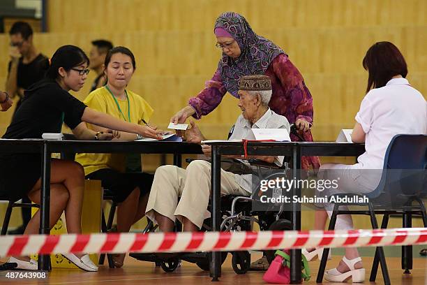 Residents line up to cast their vote at a polling station on September 11, 2015 in Singapore. About 2.5 million voters are expected to visit polling...