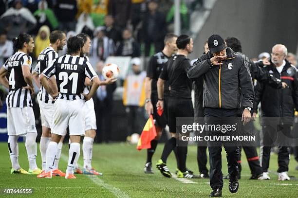 Juventus' coach Antonio Conte walk on the pitch as Juventus' players argue with Benfica's players and staff members during the UEFA Europa League...