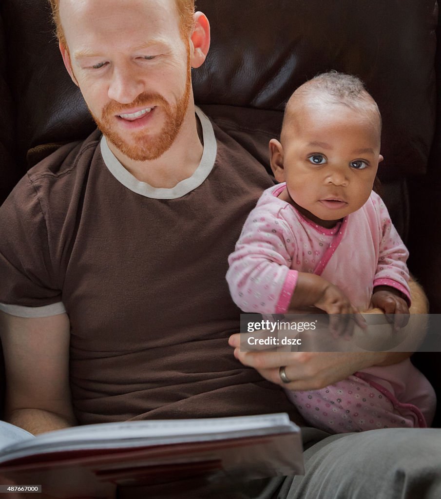 Father reading storybook, baby daughter, adopted african descent, little girl