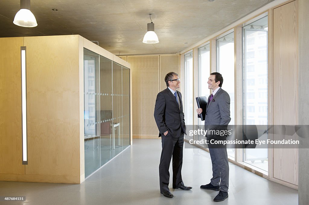 Businessmen talking in office hallway