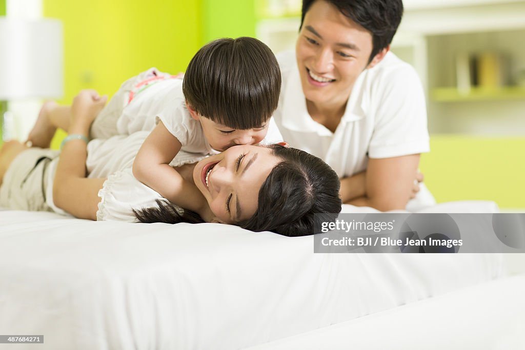 Happy family playing in bedroom