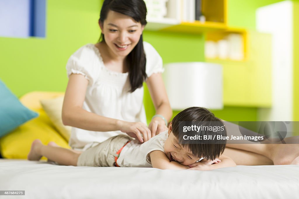 Mother and daughter playing in bedroom