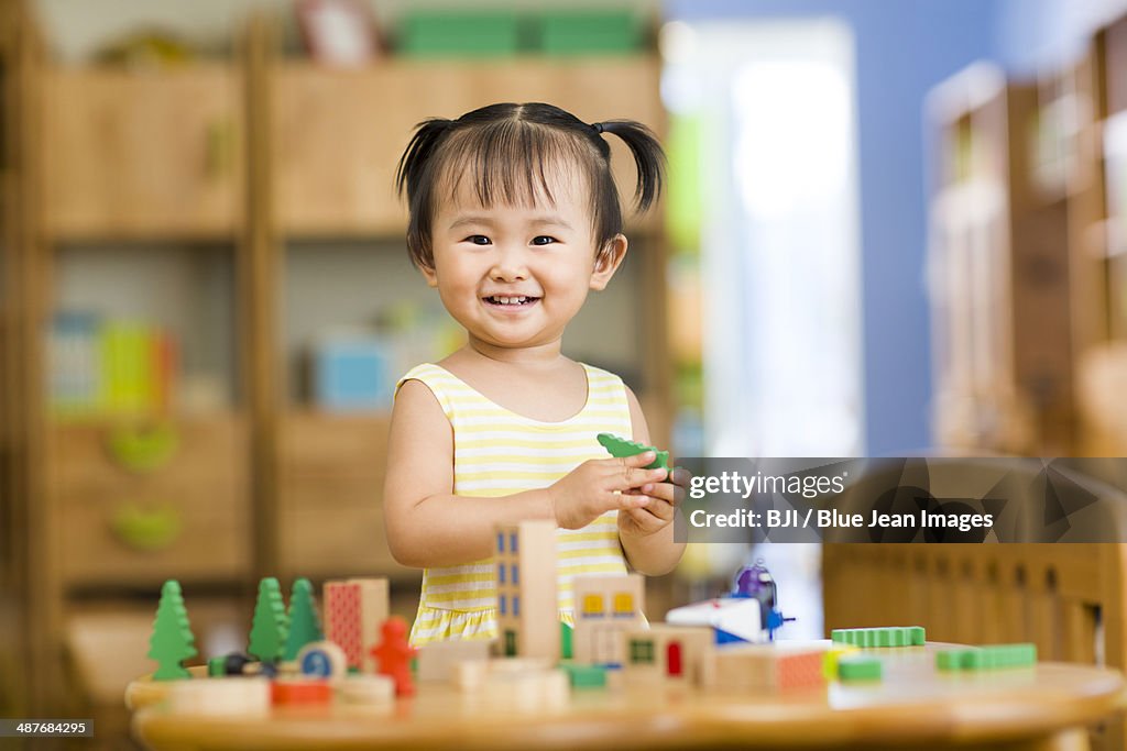 Little girl playing with toys at home