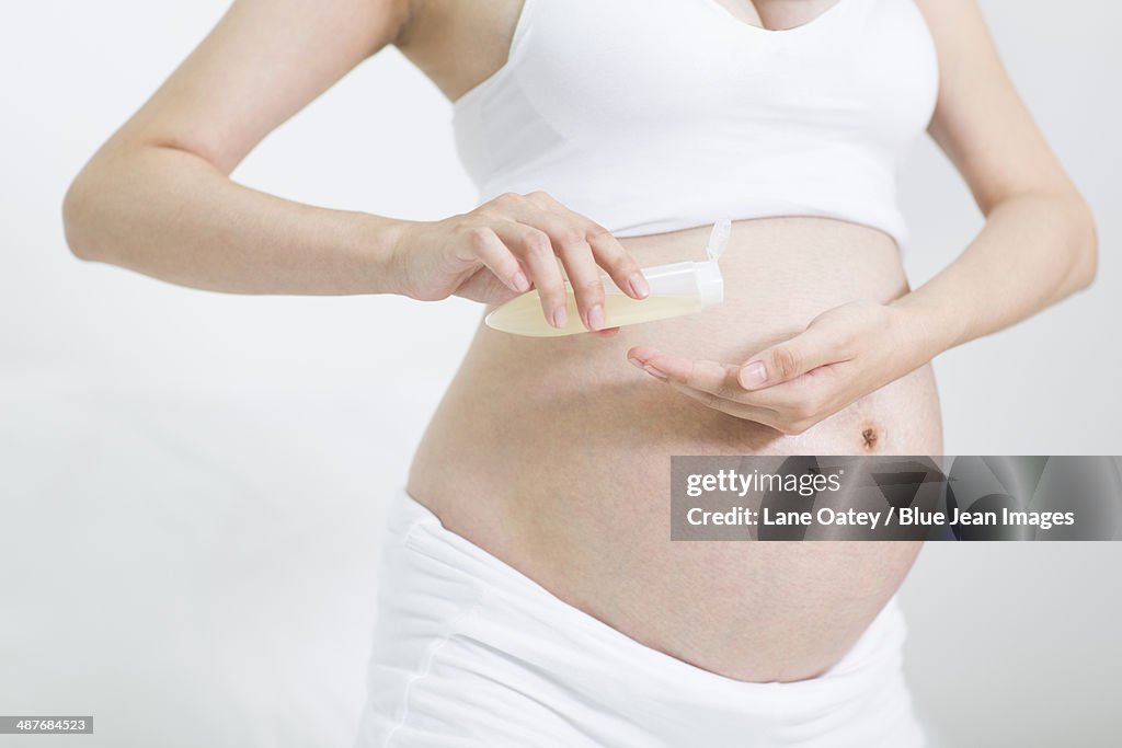 Pregnant woman using lotion