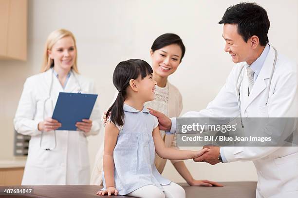 doctor talking with little girl - international mother language day stock-fotos und bilder