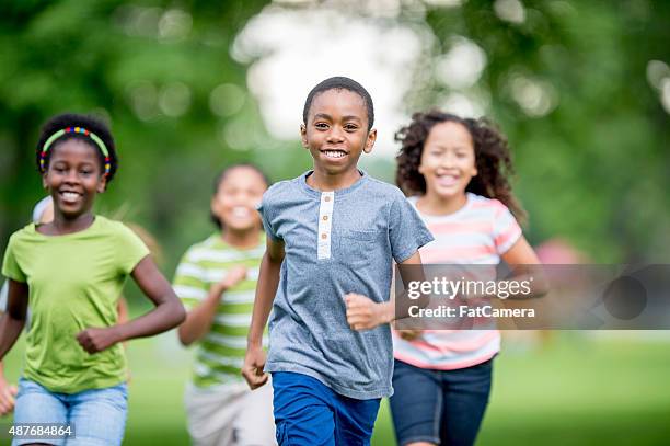 niños runnign todo en el parque - tag game fotografías e imágenes de stock