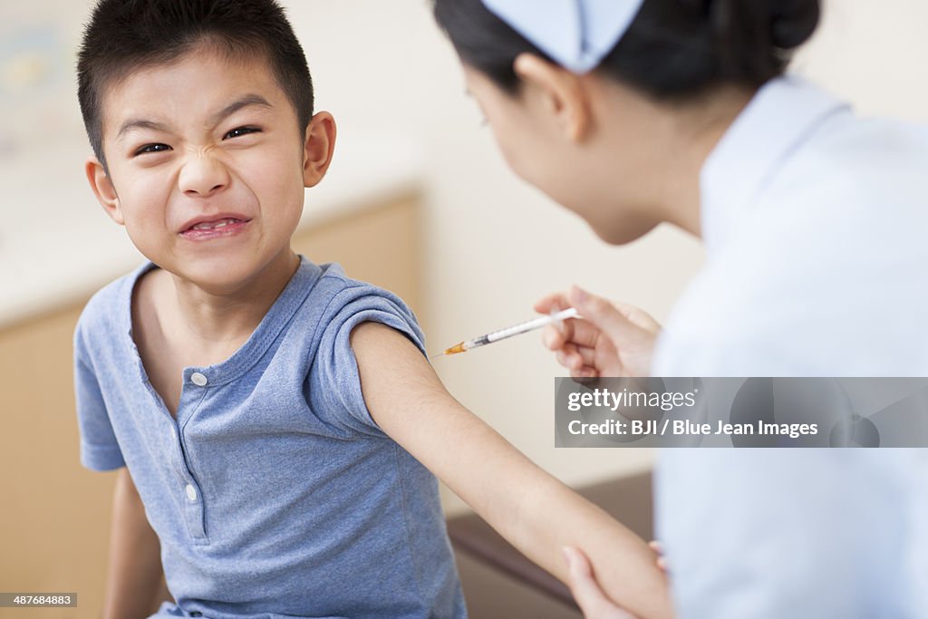 Nurse giving boy injection