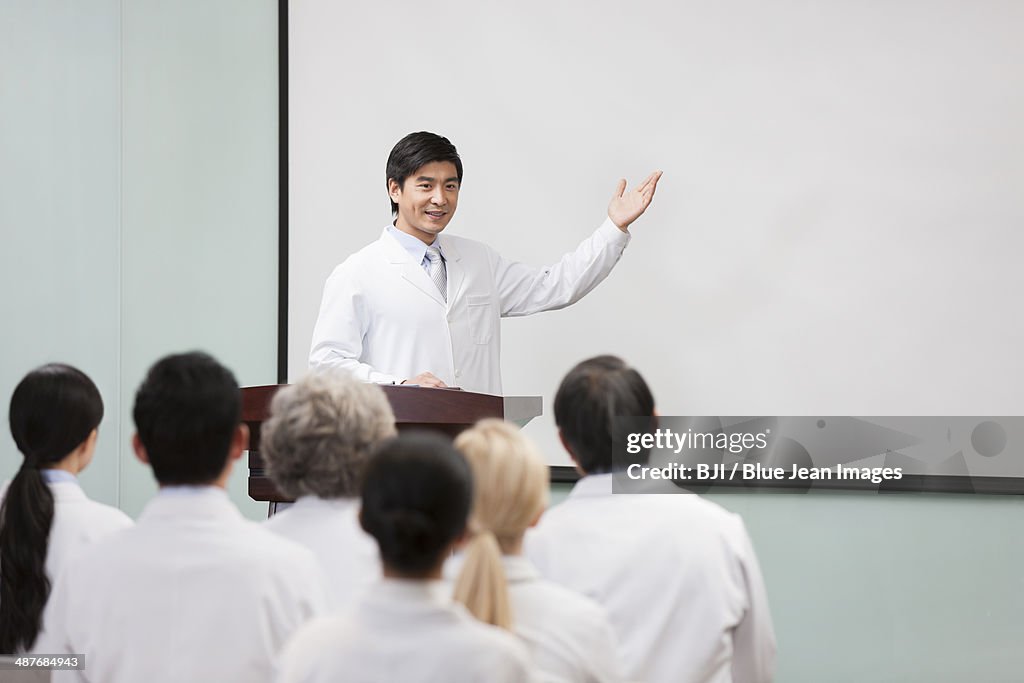 Male doctor giving speech in boardroom