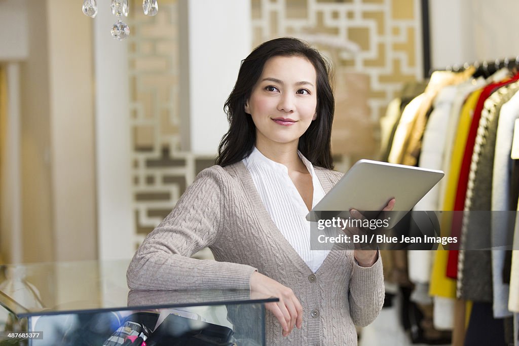 Clothing store owner with digital tablet