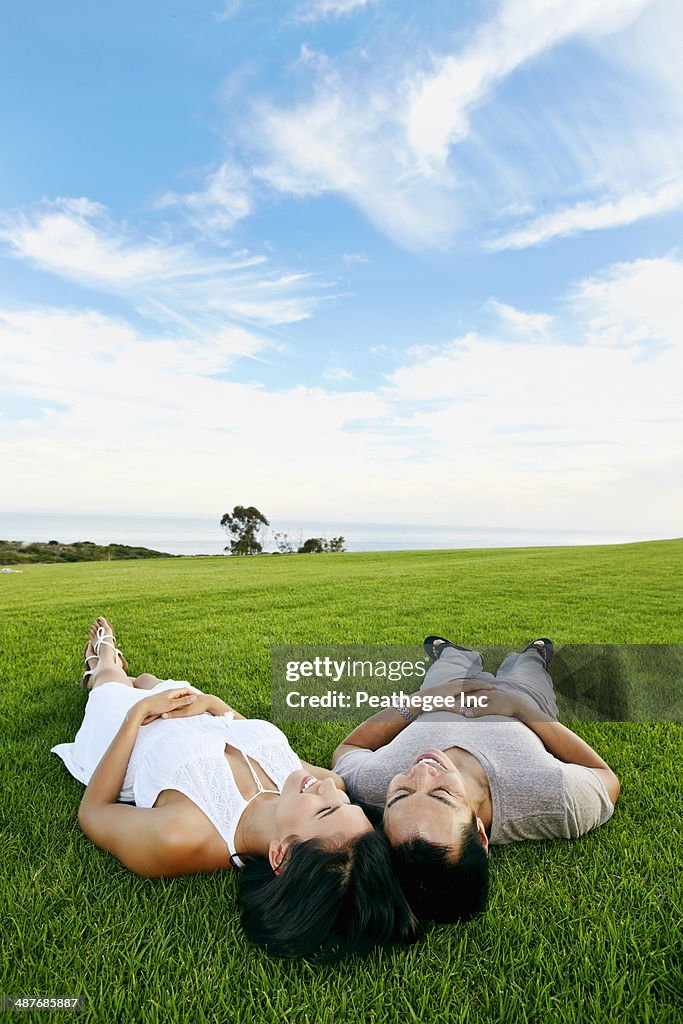 Couple laying in grass in rural landscape