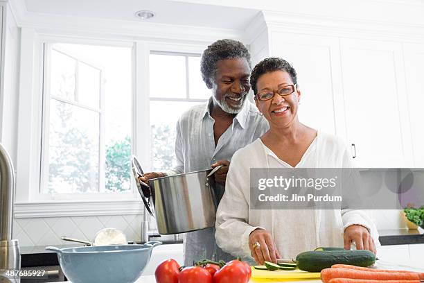 senior couple cooking in kitchen - healthy eating seniors stock pictures, royalty-free photos & images