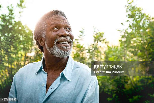senior man smiling outdoors - espoir photos et images de collection