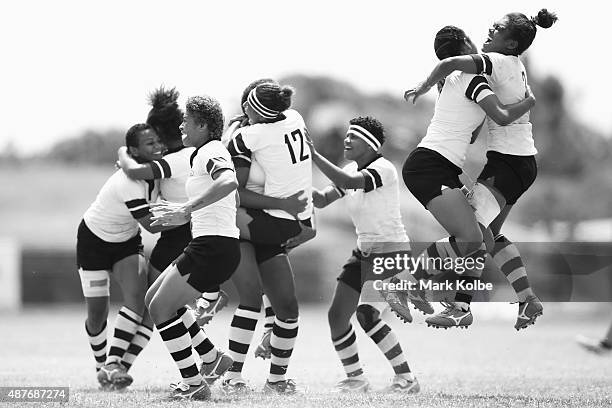 The Fiji girls rugby sevens team celebrate after defeating the Cook Islands in the girls rugby sevens bronze medal match at the Apia Park Sports...