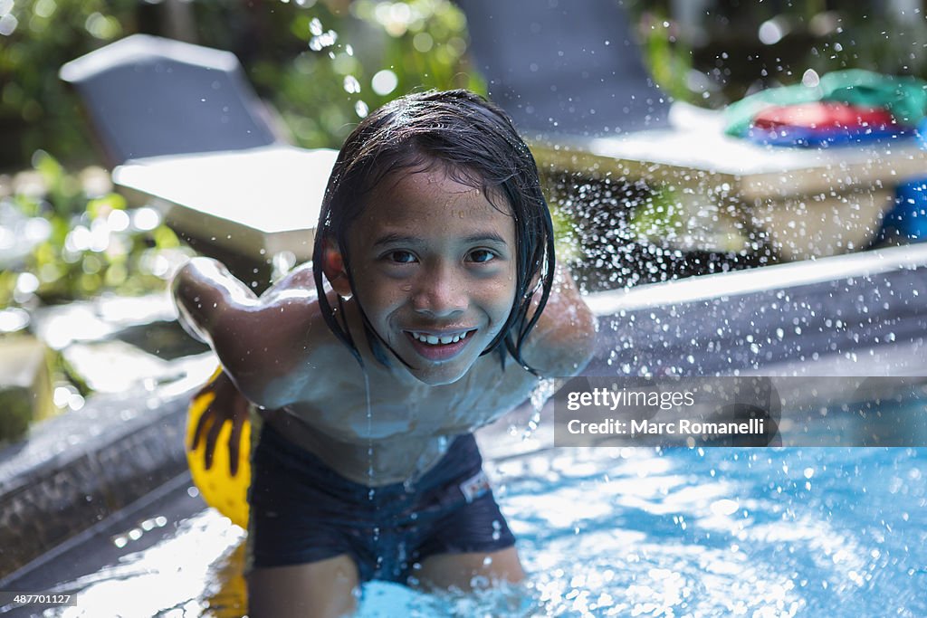 Balinese boy playing in swimming pool