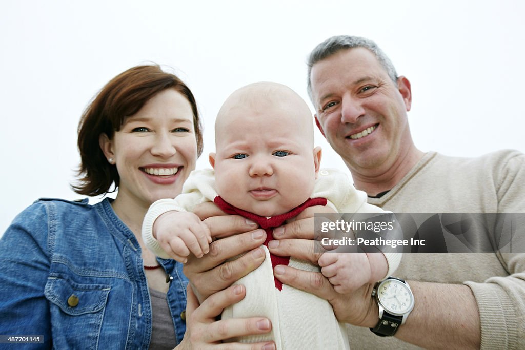Parents holding baby outdoors
