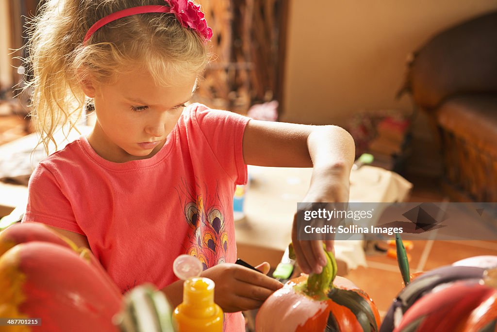Caucasian girl decorating jack o'lantern