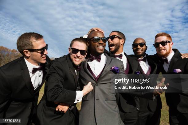 groom and groomsmen posing for wedding pictures - huwelijkspartij stockfoto's en -beelden