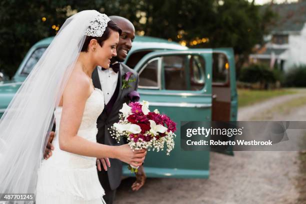 newlywed couple outside vintage car - african american wedding foto e immagini stock