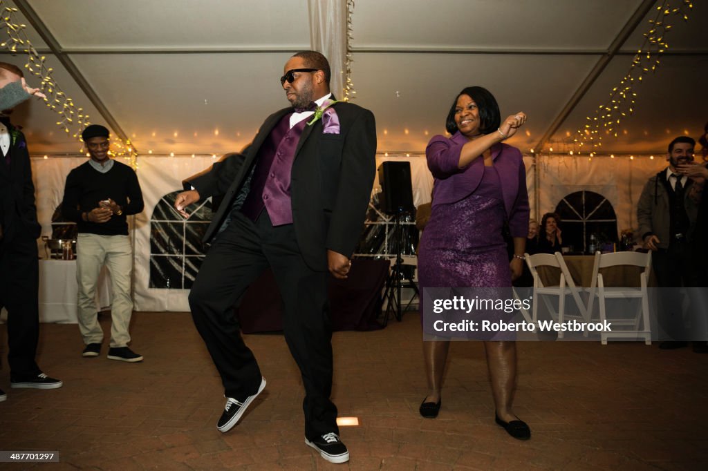 Black groom dancing with mother at reception
