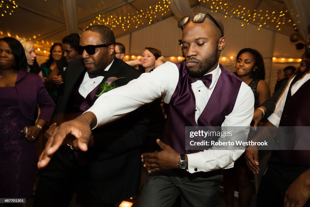 Groom and groomsman dancing at reception