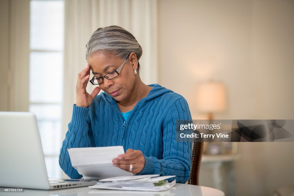 Senior African American woman paying bills