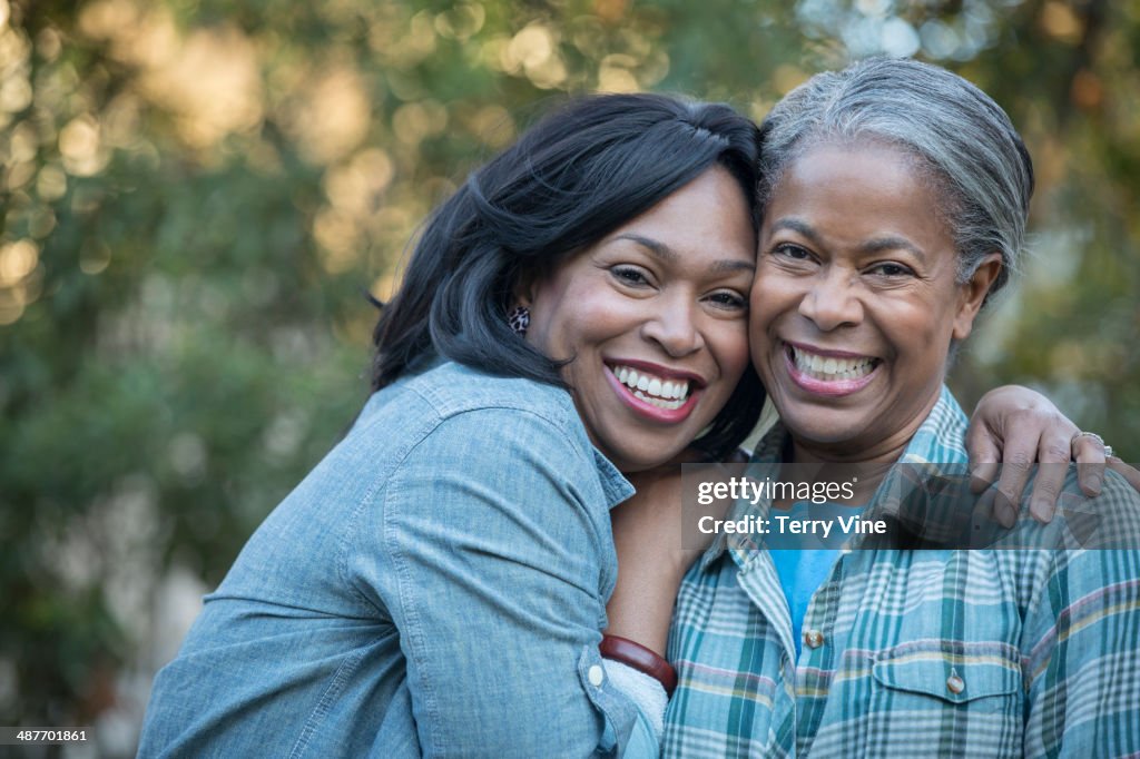 Mother and daughter hugging outdoors