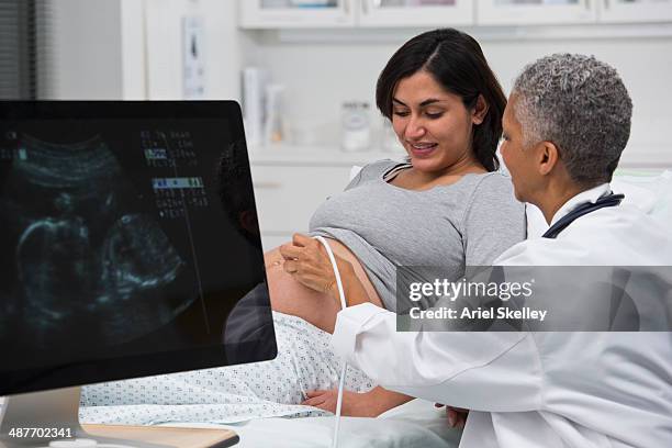 black doctor giving pregnant patient ultrasound - doctor and baby stock-fotos und bilder