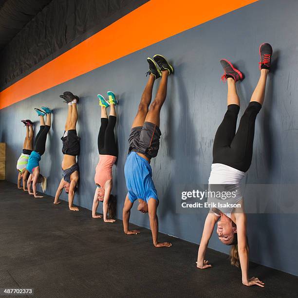 people doing handstands together in gym - handstand stock pictures, royalty-free photos & images